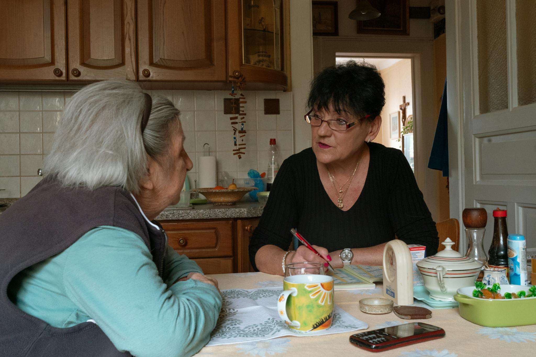 A caregiver speaking with an older adult at home