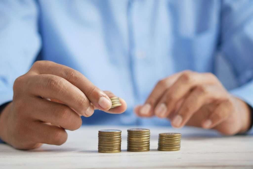 Person stacking coins while planning home care costs